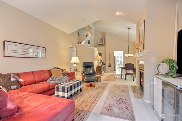 living room with light carpet, a notable chandelier, and high vaulted ceiling