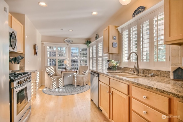 kitchen featuring sink, decorative backsplash, stainless steel appliances, and light brown cabinets