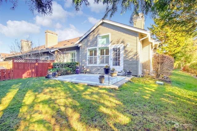 back of property with a yard and a patio area