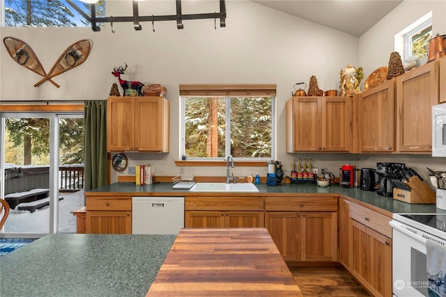 kitchen with high vaulted ceiling, sink, and white appliances