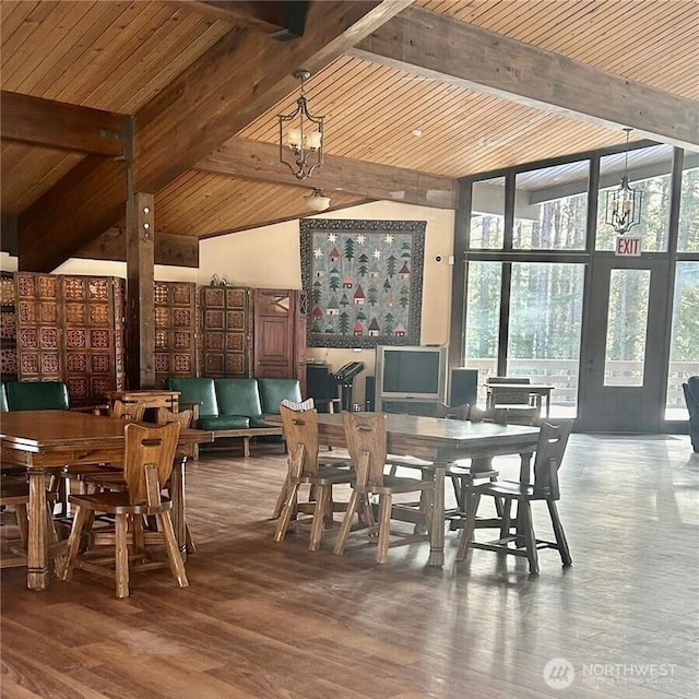 dining space featuring hardwood / wood-style flooring, beamed ceiling, and a chandelier