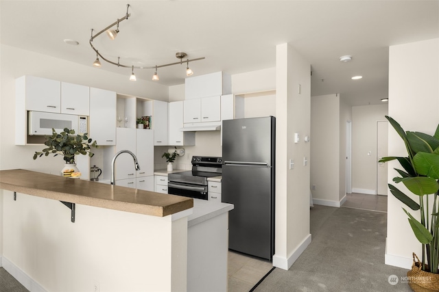 kitchen featuring white cabinetry, appliances with stainless steel finishes, kitchen peninsula, and a breakfast bar area