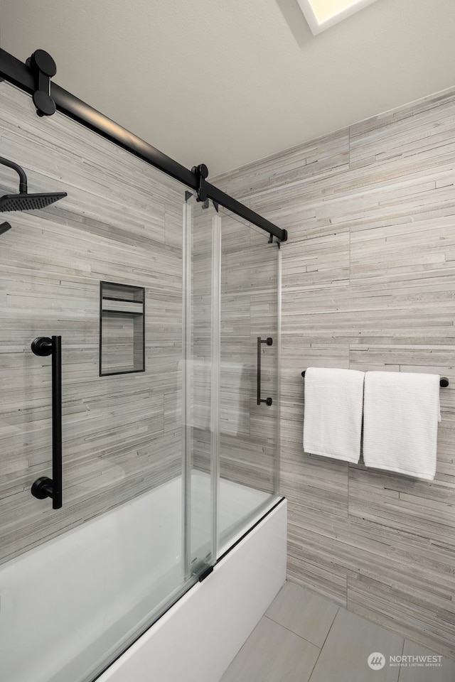 bathroom featuring tile patterned flooring and enclosed tub / shower combo