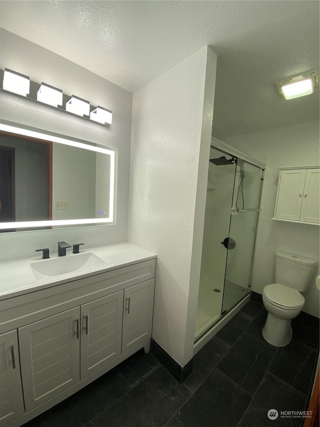 bathroom featuring walk in shower, toilet, and a textured ceiling