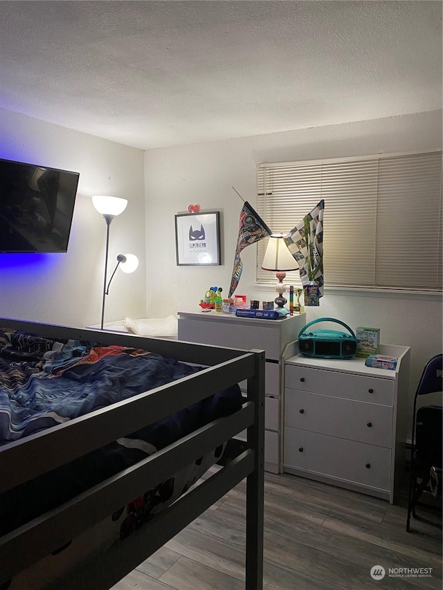 bedroom featuring dark hardwood / wood-style flooring and a textured ceiling