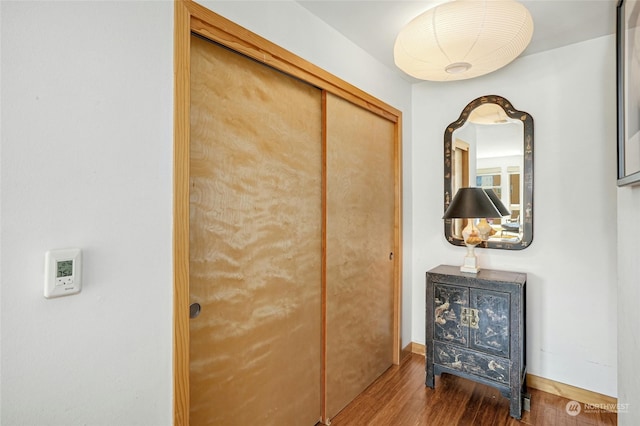 hall with baseboards and wood finished floors