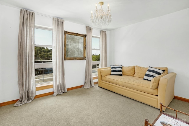 carpeted living area featuring a notable chandelier and baseboards