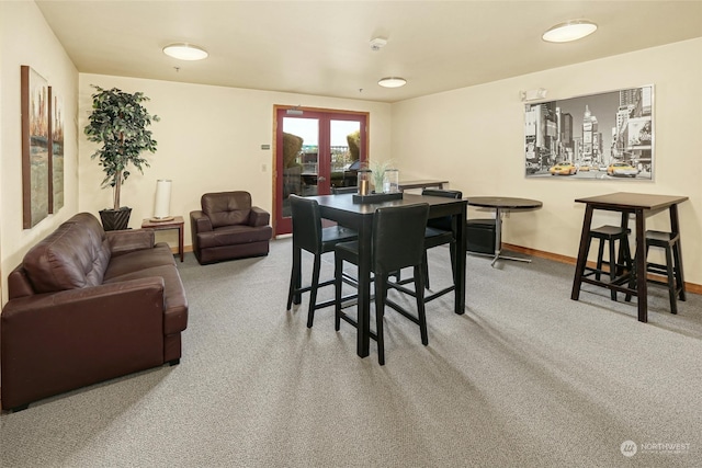 carpeted dining area with french doors and baseboards