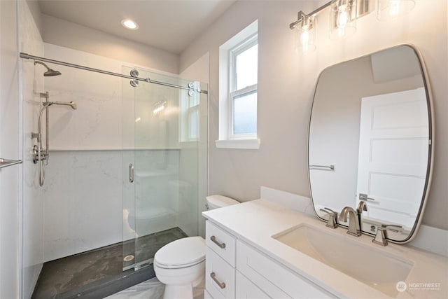 bathroom featuring toilet, vanity, and a shower with shower door