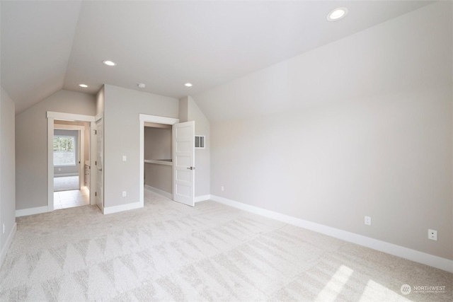 interior space with lofted ceiling and light carpet