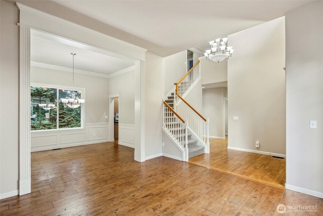 interior space with hardwood / wood-style floors, ornamental molding, and a chandelier