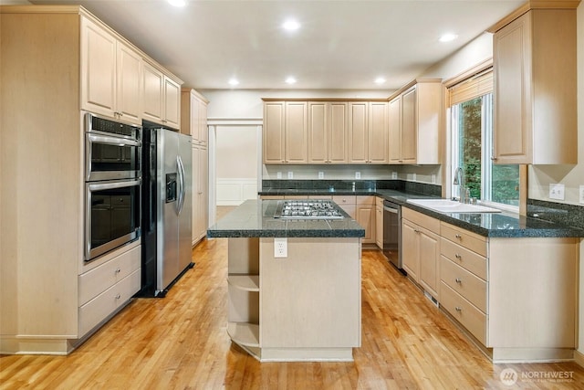 kitchen featuring stainless steel appliances, a center island, sink, and light hardwood / wood-style floors