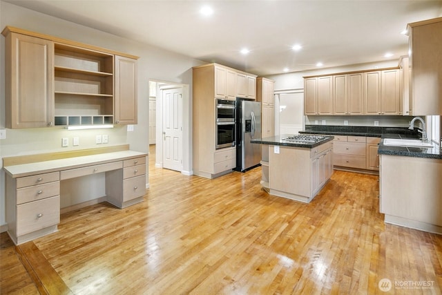 kitchen with stainless steel appliances, a center island, sink, and light wood-type flooring