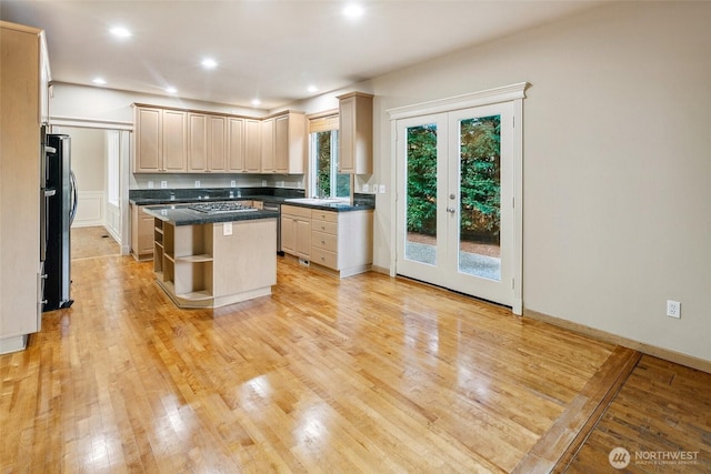 kitchen featuring stainless steel appliances, light hardwood / wood-style flooring, light brown cabinets, and a kitchen island