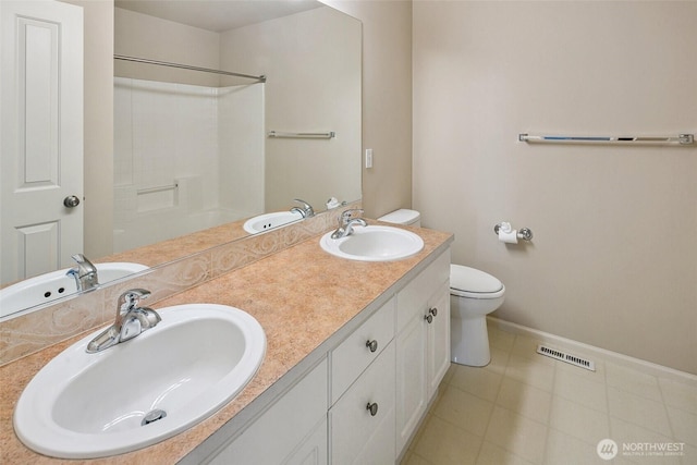 bathroom with vanity, tile patterned flooring, toilet, and walk in shower