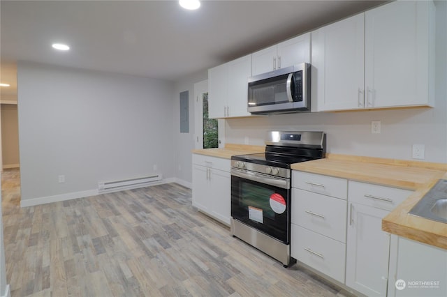 kitchen featuring light hardwood / wood-style flooring, appliances with stainless steel finishes, white cabinetry, a baseboard heating unit, and butcher block counters