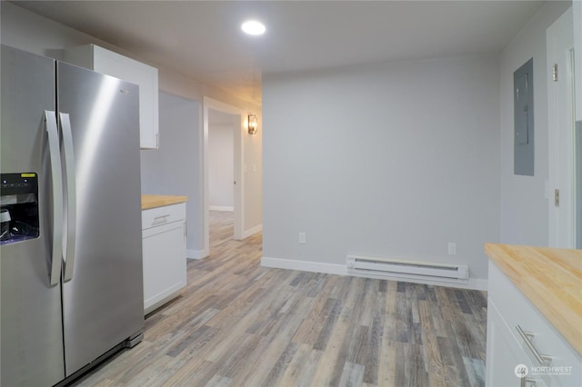 kitchen with butcher block countertops, stainless steel fridge, white cabinetry, light hardwood / wood-style floors, and a baseboard radiator