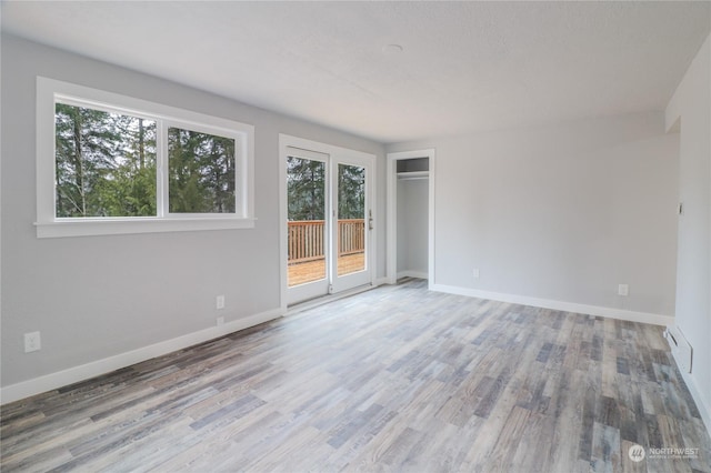 unfurnished room with hardwood / wood-style flooring and a wealth of natural light