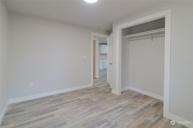 unfurnished bedroom featuring a closet and light wood-type flooring