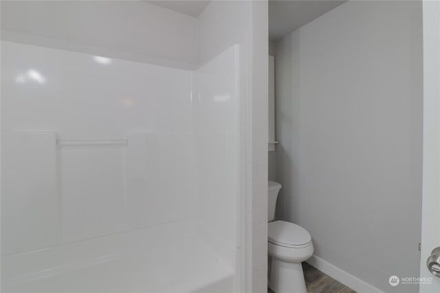 bathroom featuring wood-type flooring, a shower, and toilet