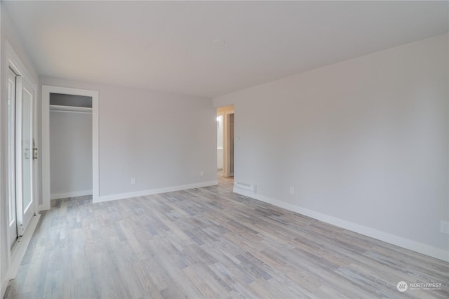 unfurnished bedroom featuring light hardwood / wood-style flooring and a closet