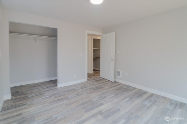 unfurnished bedroom with light hardwood / wood-style flooring and a closet