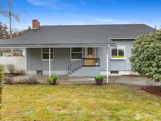 view of front of home featuring a shingled roof, a chimney, and a front yard