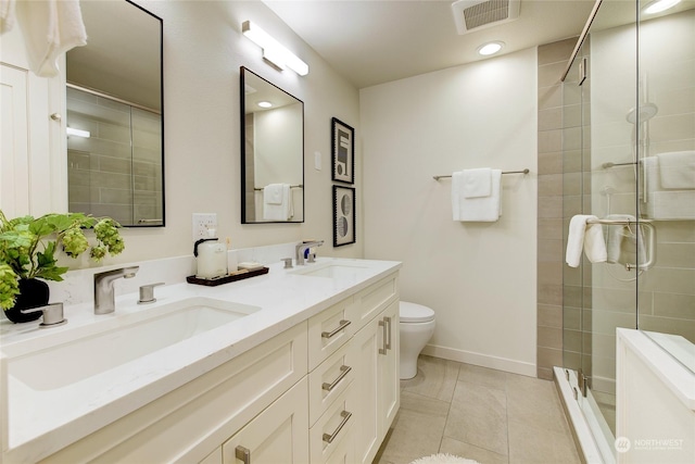 bathroom featuring tile patterned flooring, vanity, toilet, and walk in shower