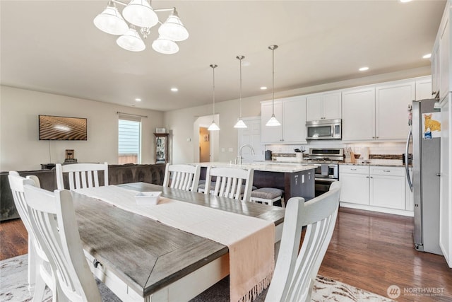 dining space featuring a chandelier, recessed lighting, and dark wood-style flooring