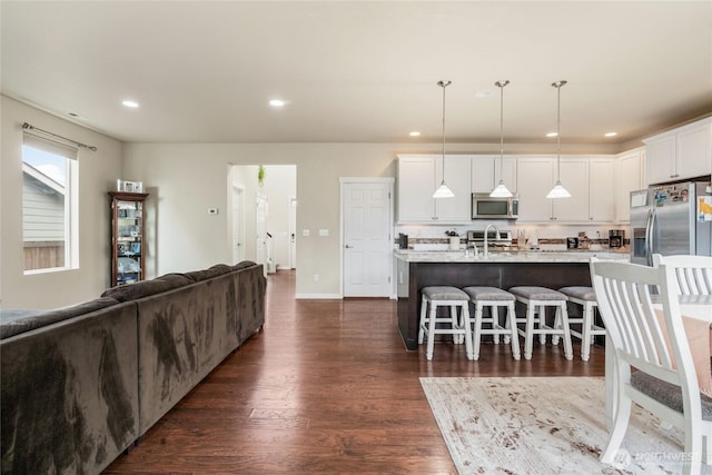 living area featuring dark wood finished floors, recessed lighting, and baseboards