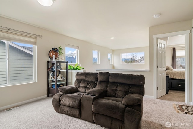 carpeted living area with visible vents, baseboards, and a healthy amount of sunlight