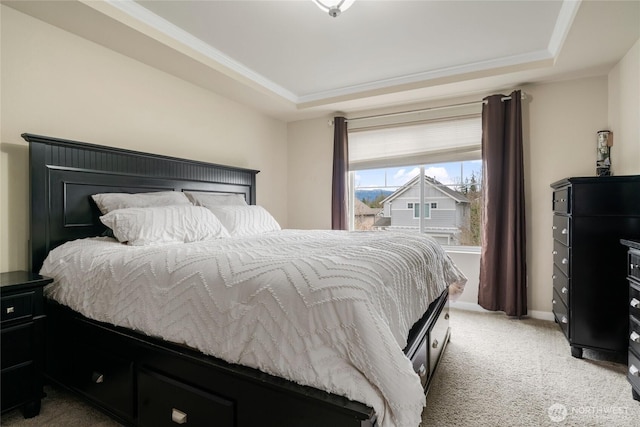 bedroom with a tray ceiling, baseboards, light colored carpet, and ornamental molding