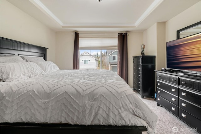 bedroom featuring a raised ceiling, light colored carpet, and ornamental molding