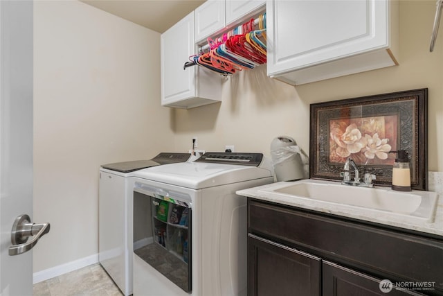 laundry area with a sink, baseboards, cabinet space, and independent washer and dryer