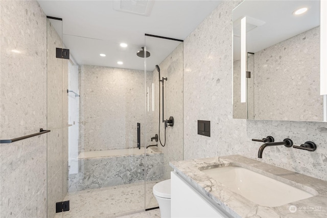 bathroom with tile walls, an enclosed shower, vanity, and toilet