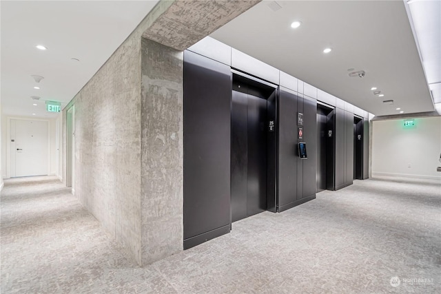 hall featuring elevator and light carpet