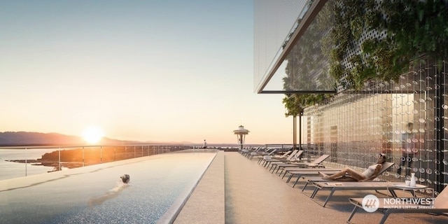 patio terrace at dusk featuring a water view