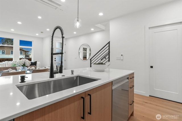 kitchen with hanging light fixtures, light countertops, stainless steel dishwasher, and open floor plan