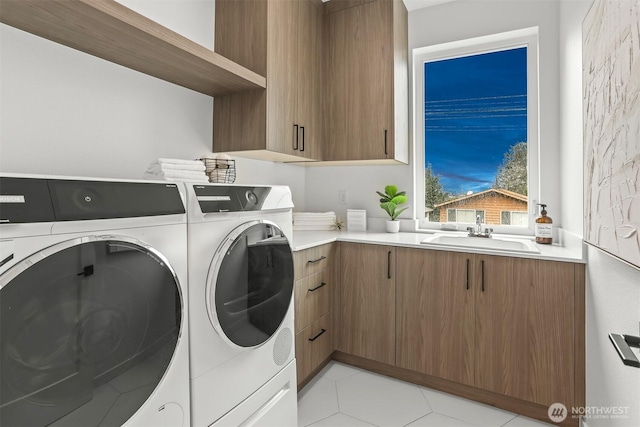 laundry room featuring light tile patterned floors, independent washer and dryer, a sink, and cabinet space