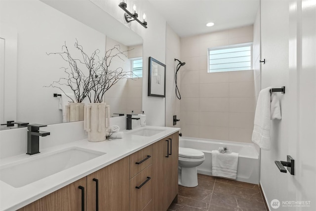 bathroom featuring bathtub / shower combination, a sink, toilet, and double vanity