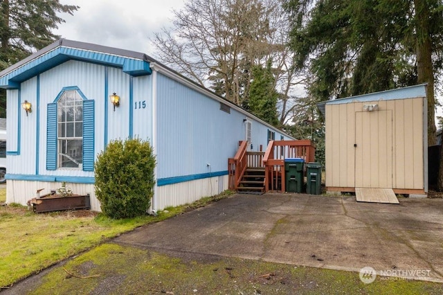 view of side of home featuring a patio area and a shed