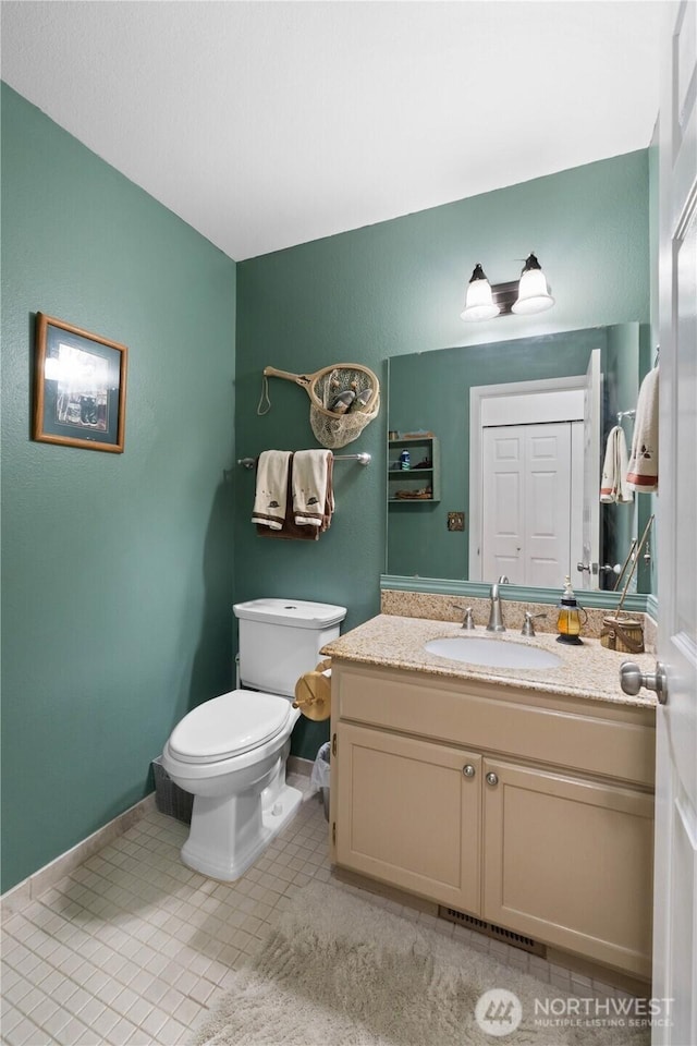 bathroom featuring visible vents, baseboards, toilet, tile patterned flooring, and vanity