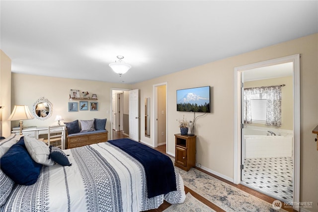 bedroom featuring baseboards and ensuite bathroom