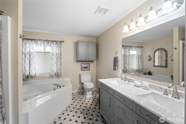 bathroom featuring visible vents, a sink, toilet, and a bath