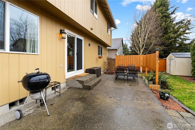 view of patio / terrace featuring entry steps, area for grilling, an outdoor structure, fence, and a shed