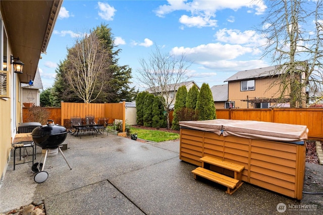 view of patio / terrace with outdoor dining area, a fenced backyard, a hot tub, and area for grilling