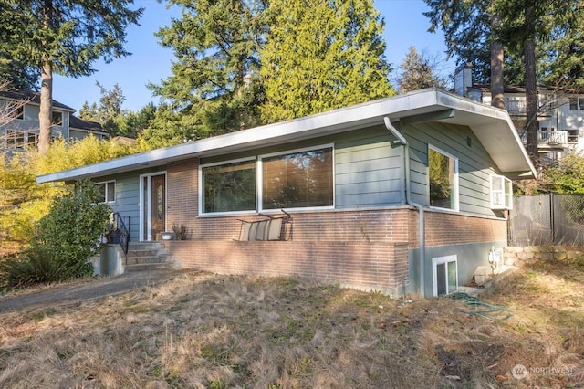 view of side of property with fence and brick siding