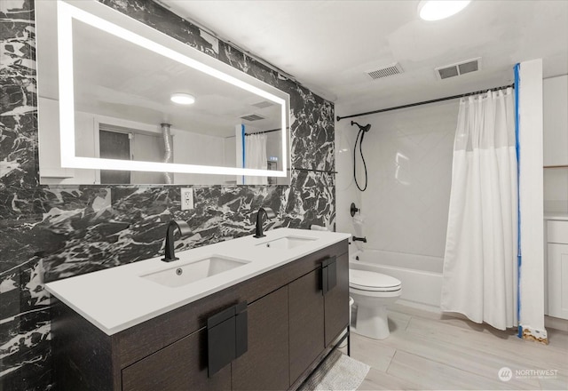 bathroom with shower / bathtub combination with curtain, visible vents, and a sink