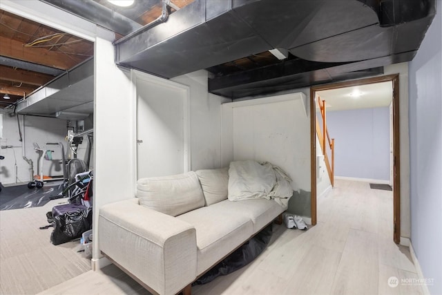 finished basement featuring stairs, baseboards, and wood finished floors