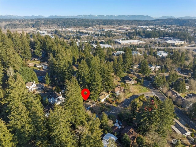 birds eye view of property featuring a mountain view and a view of trees